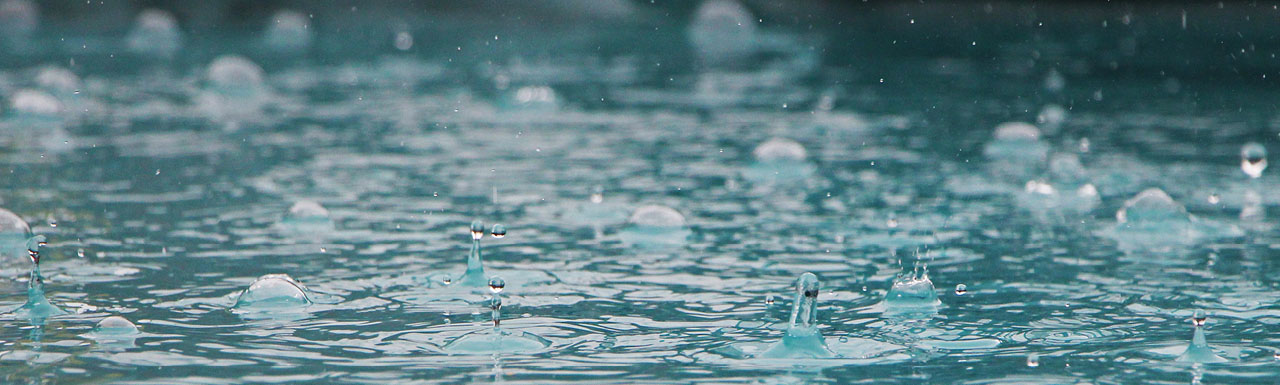 Raindrops splashing on water
