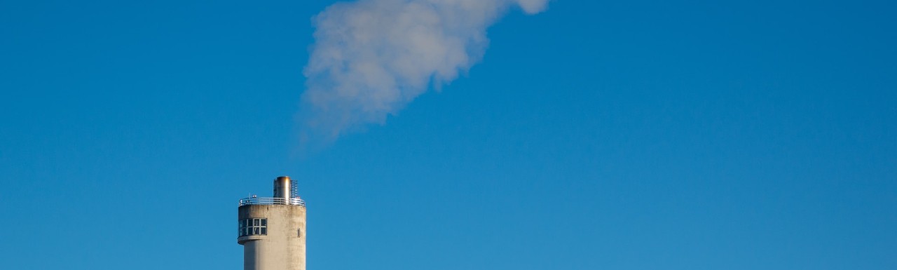 Smoke coming out of a chimney on a building Smoke coming out of a chimney on a building
