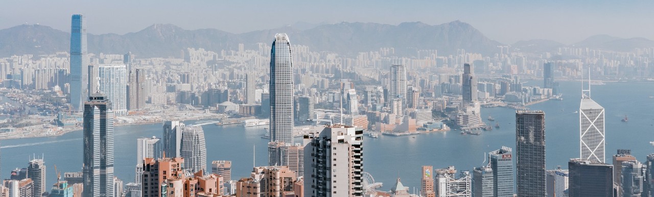 A helicopter view of a city during day time and an ocean in the center