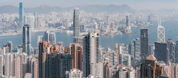 A helicopter view of a city during day time and an ocean in the center A helicopter view of a city during day time and an ocean in the center